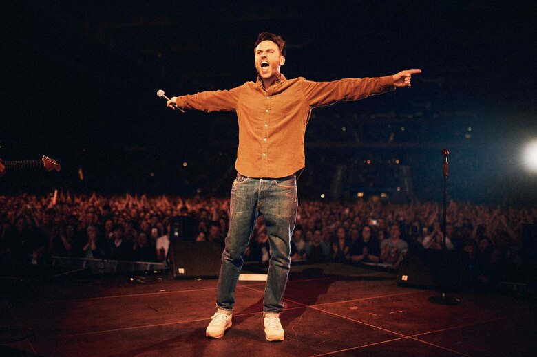 Ein Mann steht auf einer Bühne.