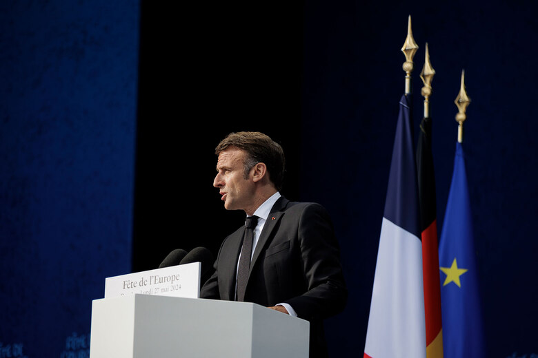 Ein Mann steht hinter einem Pult auf einer Bühne und hält eine Rede.