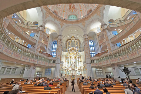 Männer und Frauen sitzen in einer Kirche.