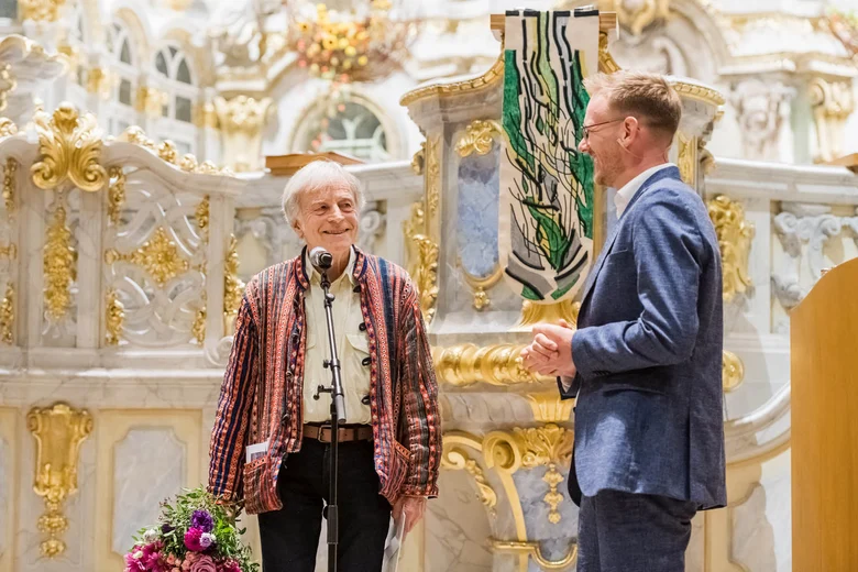 Zwei Männer stehen vor einem Altar.