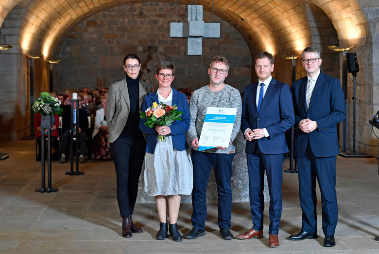 Männer und Frauen posieren für ein Foto.